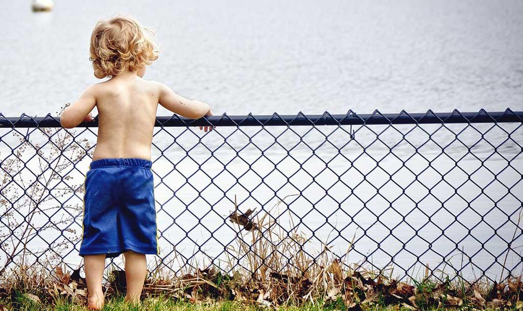 Young-boy-standing-infront-of-a-lake
